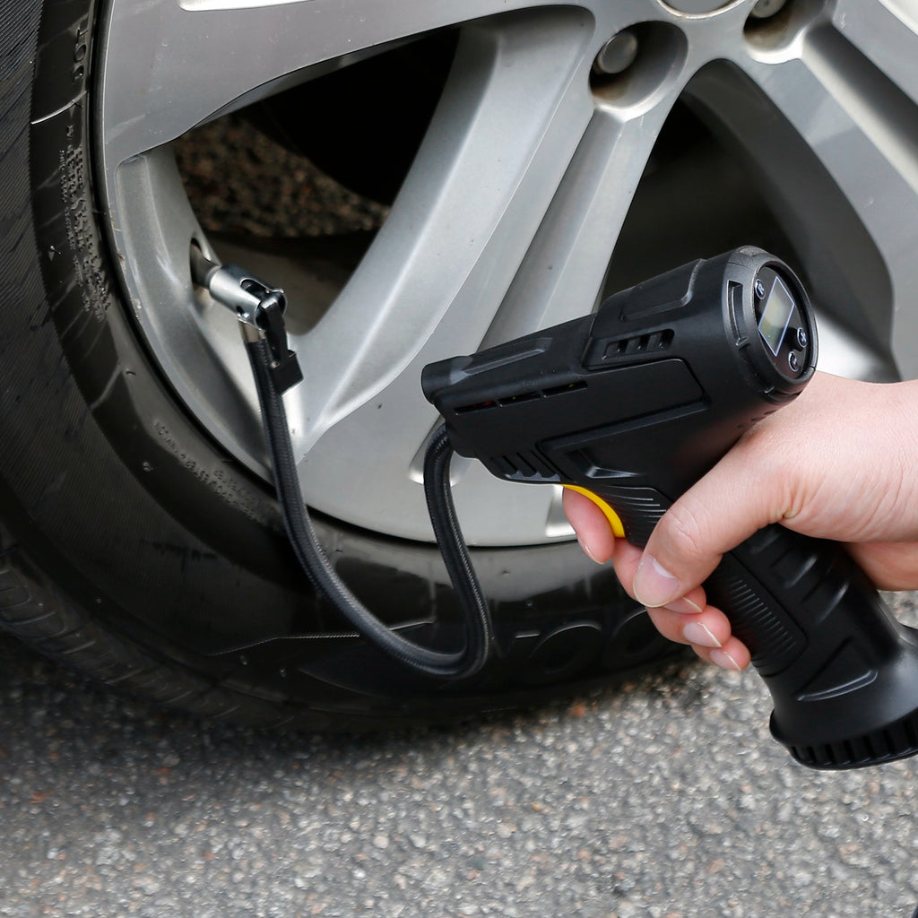 Portable Car Tire Inflator with digital display connected to a car tire valve