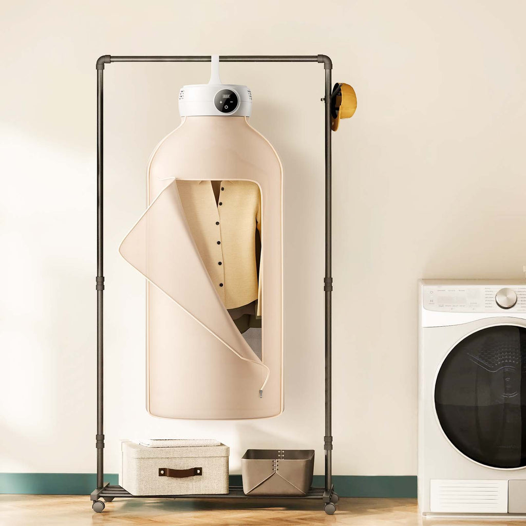 Portable clothes dryer with beige fabric cover hanging from a clothes rack next to a washing machine