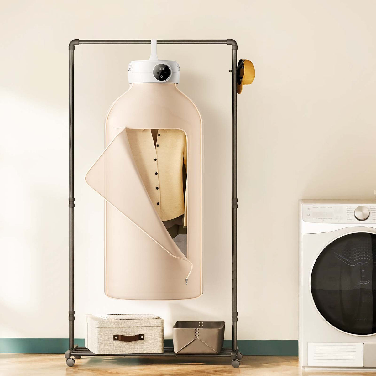 Portable clothes dryer with beige fabric cover hanging from a clothes rack next to a washing machine