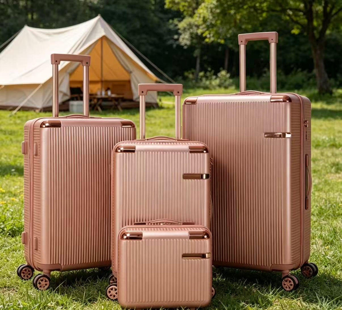 Rose gold luggage set of four on the grass in front of a white tent
